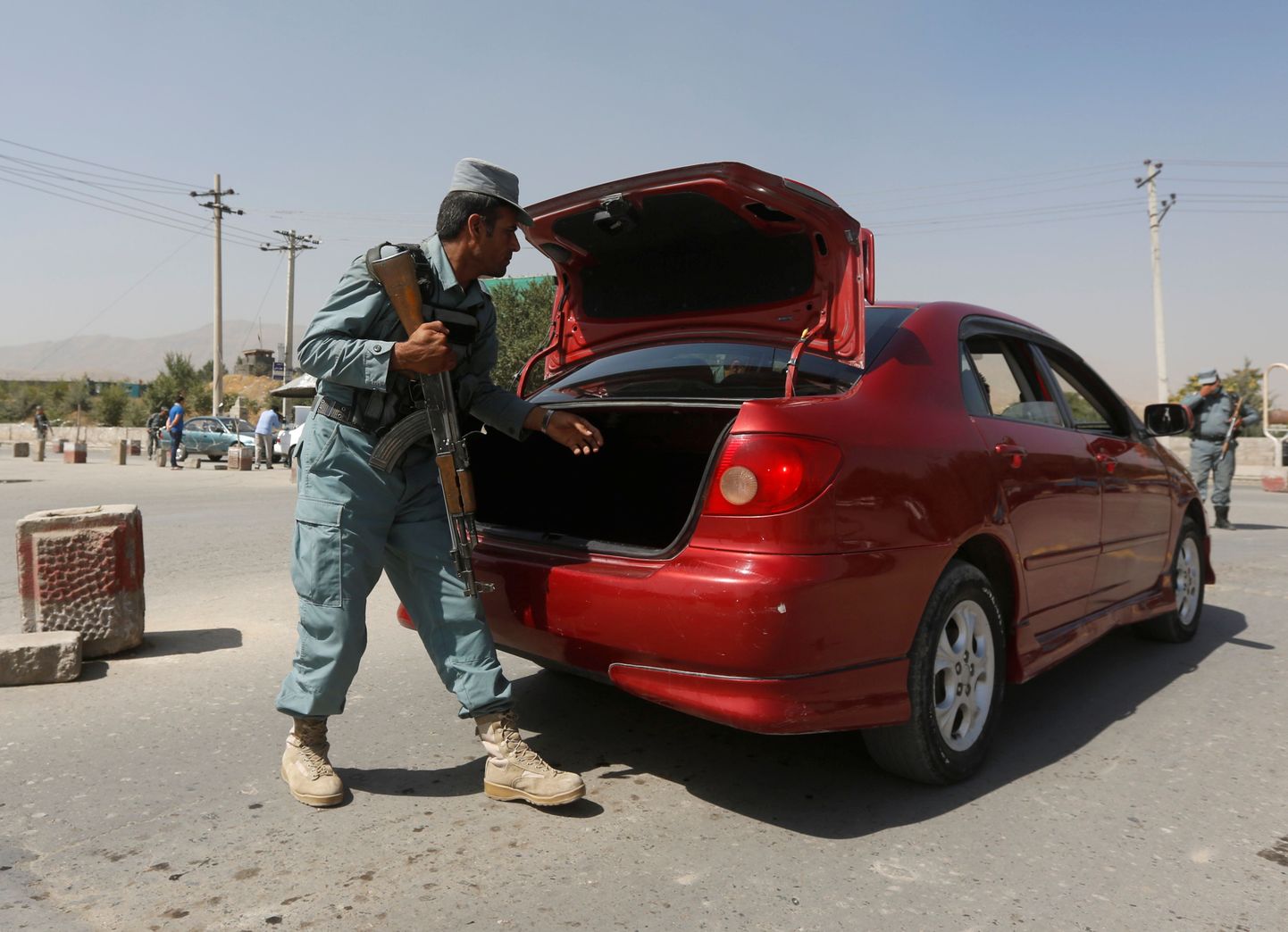 Afganistani politseinik kontrollimas autot inimröövi piirkonna läheduses.