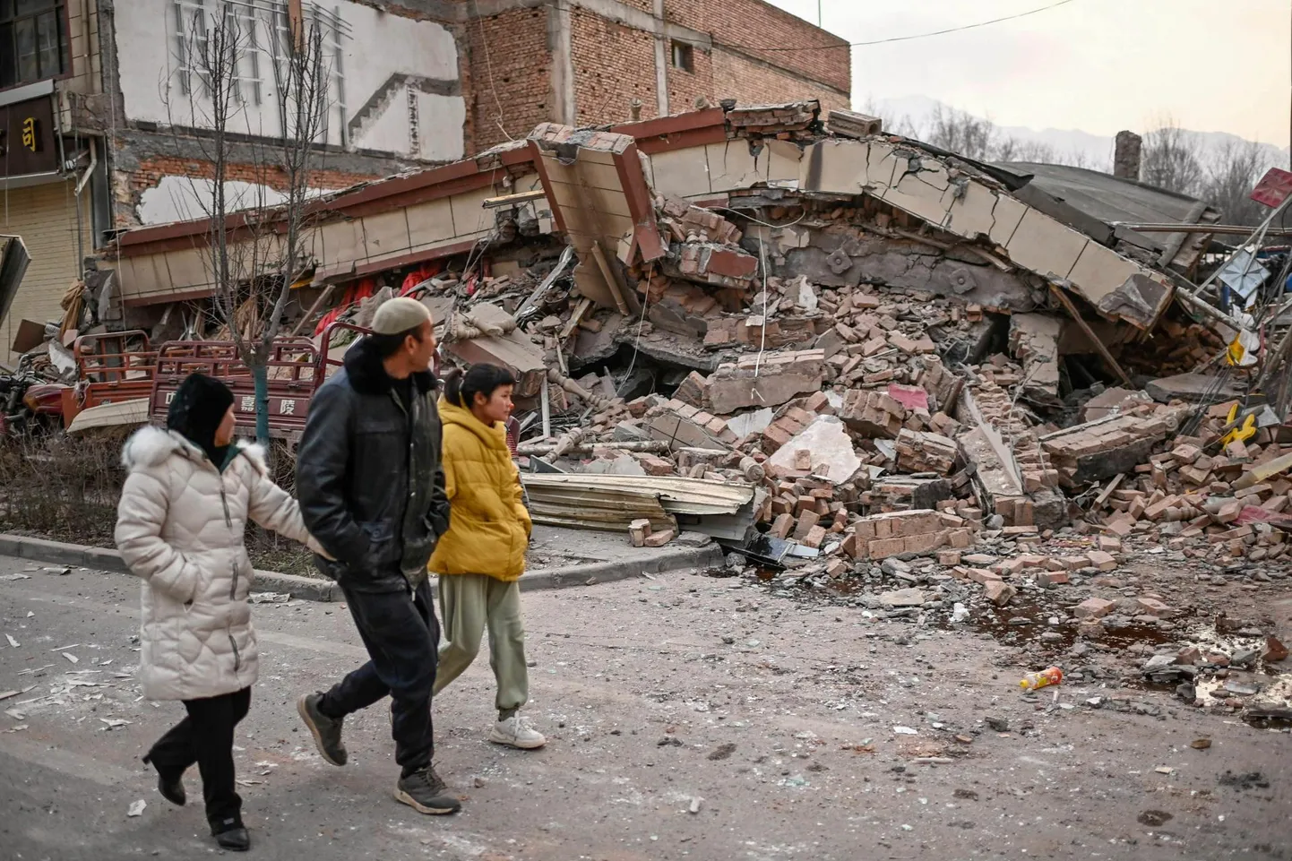 Inimesed möödumas Jishishani maakonnas maavärinas kokku varisenud hoonest.