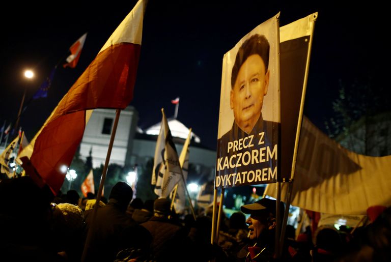 Meeleavaldajad olid Varssavis asuva seimihoone ette kogunenud ka eile õhtul. Üks protesteerija hoidis käes plakatit, kus PiS-i esimeest Jarosław Kaczyńskit kujutatati Põhja-Korea liidri Kim Jong-un'ina. FOTO: KACPER PEMPEL/REUTERS/Scanpix