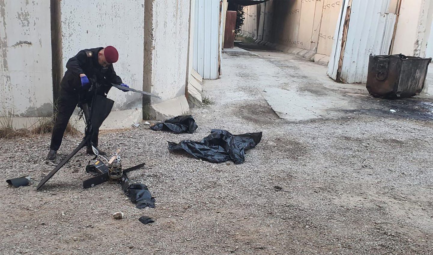 Koalitsioonijõudude ametnik uurimas Bagdadis allatulistatud drooni tükke.
