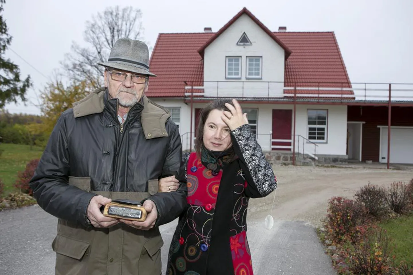 Külli Hiiemäe-Metsar ja Aago Metsar oma kodumaja ees kogukonna pärli meenega.
